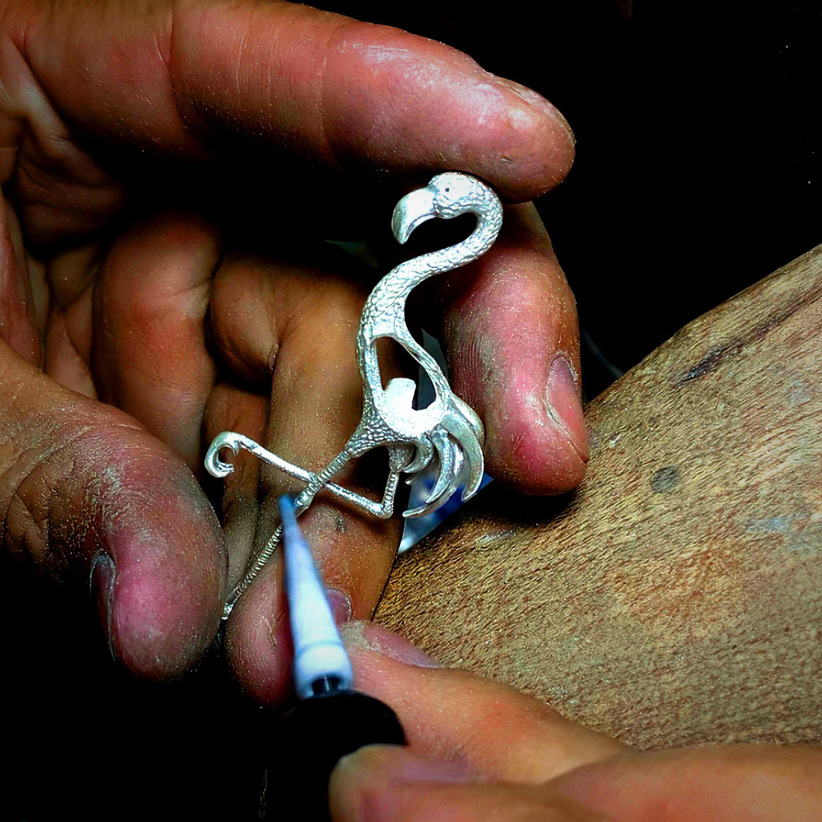 Hand-finishing a handmade sterling silver jewelry piece at the HEWREN artisan workbench
