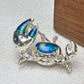 iridescent blue-green enamel shore crab silver brooch detail — jewelry close-up photo