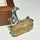 Sterling silver curled leopard brooch pinned to textile — handmade jewelry detail