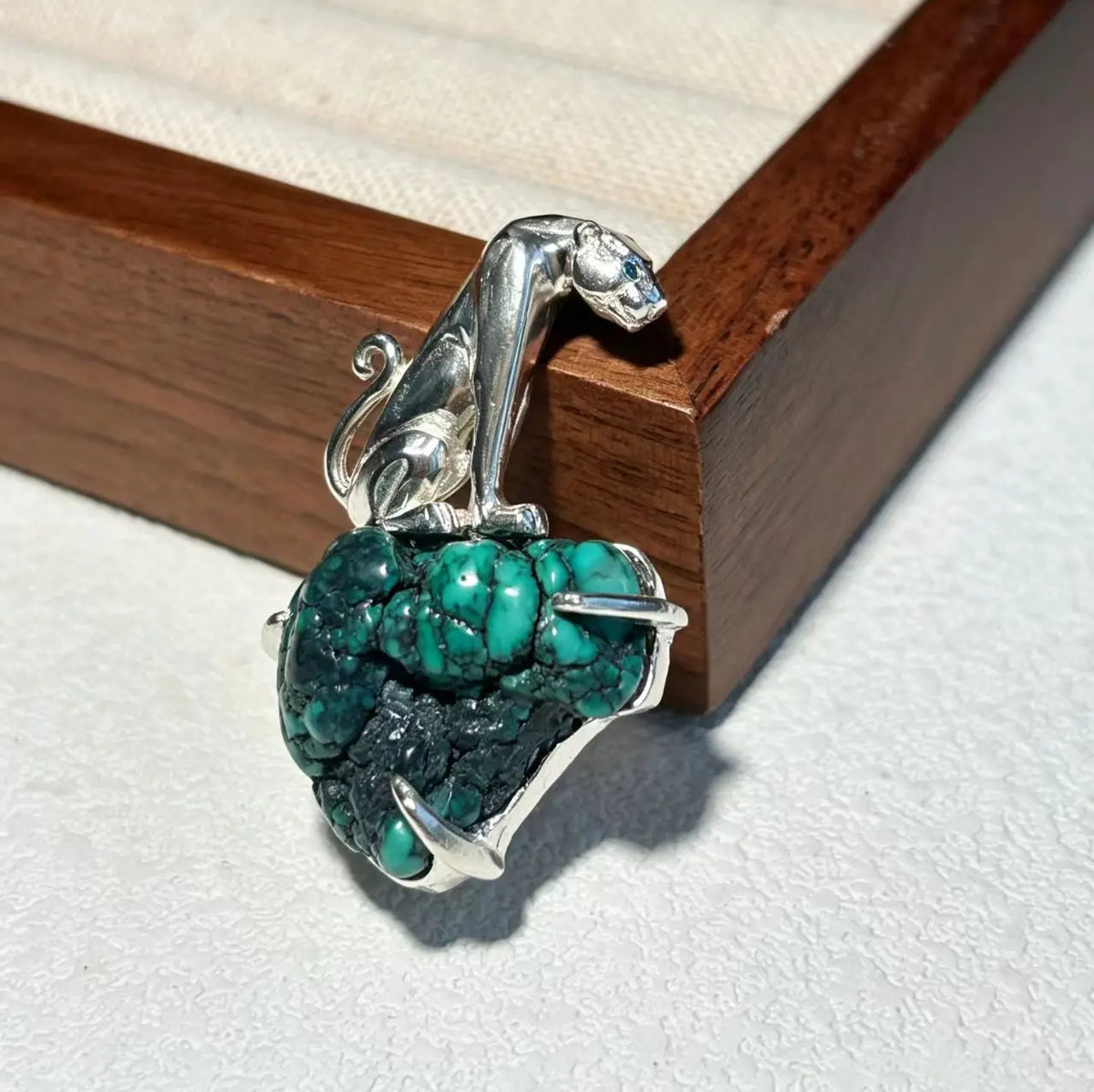 Convertible seated leopard silver pendant and brooch in a styling photo