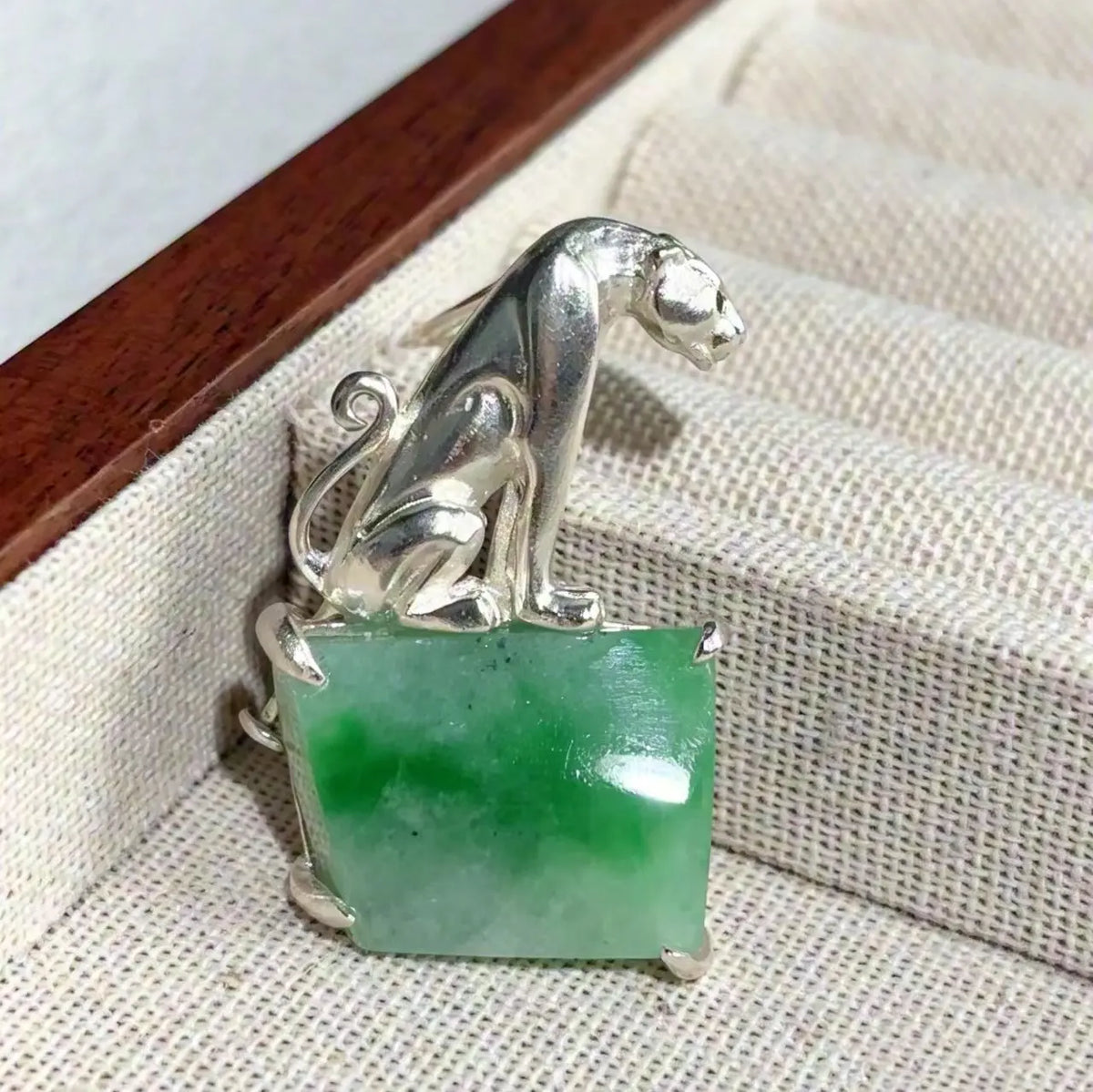 Sterling silver regal leopard brooch pinned to textile — handmade jewelry detail