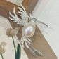 Artisan sterling silver fluttering hummingbird brooch styling detail with freshwater pearl