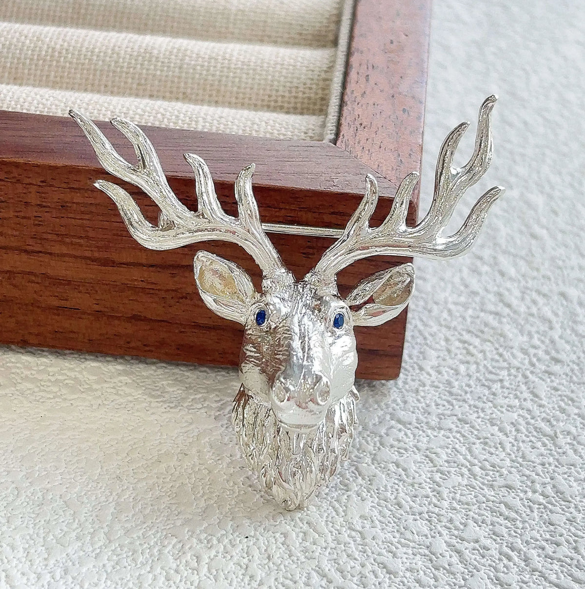Sterling silver majestic stag brooch pinned to textile — handmade jewelry detail