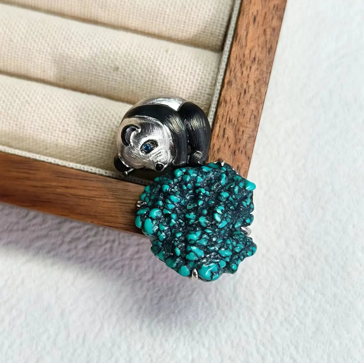 Sterling silver serene panda brooch pinned to textile — handmade jewelry detail
