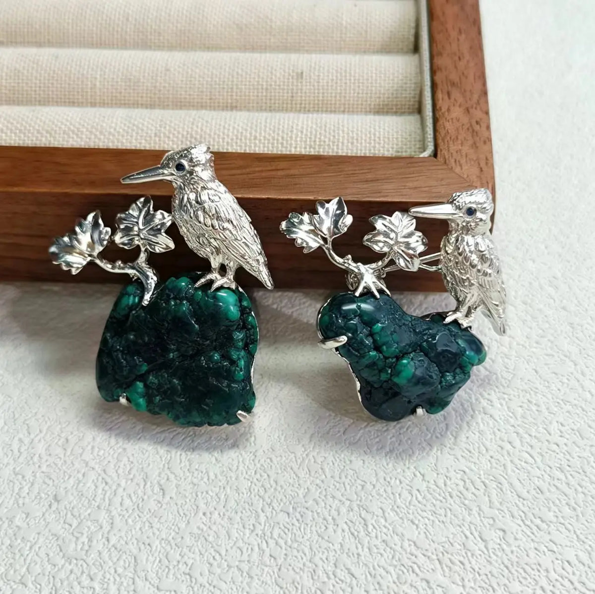 Sterling silver autumn maple leaf bird brooch pinned to textile — handmade jewelry detail