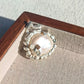Convertible radiant sunflower silver pendant and brooch in a styling photo