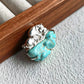 Sterling silver mother & calf hippo brooch pinned to textile — handmade jewelry detail