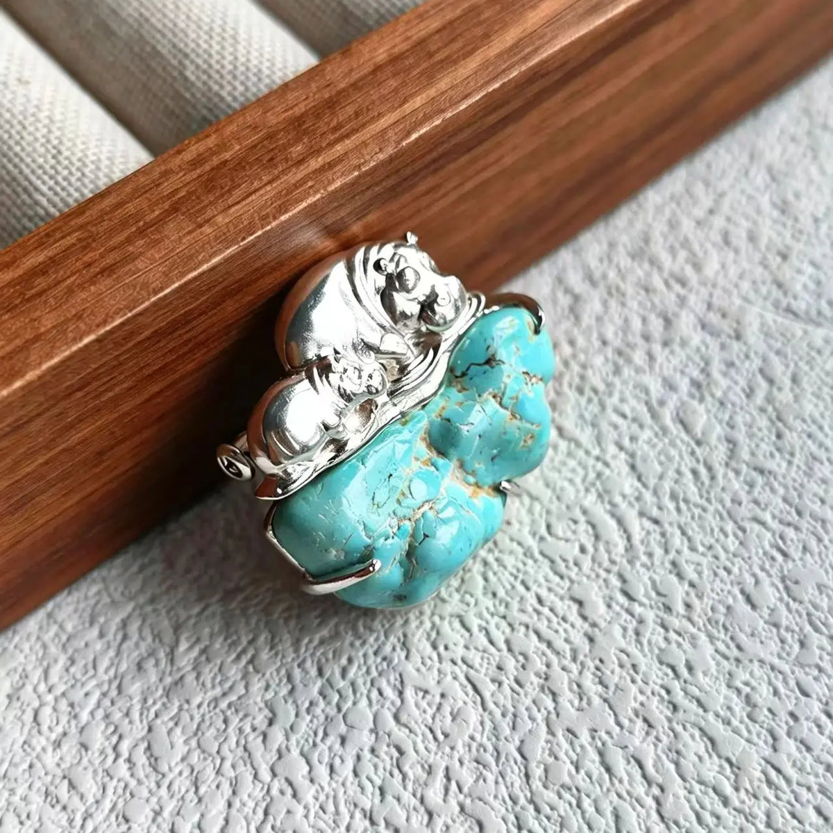 Sterling silver mother & calf hippo brooch pinned to textile — handmade jewelry detail